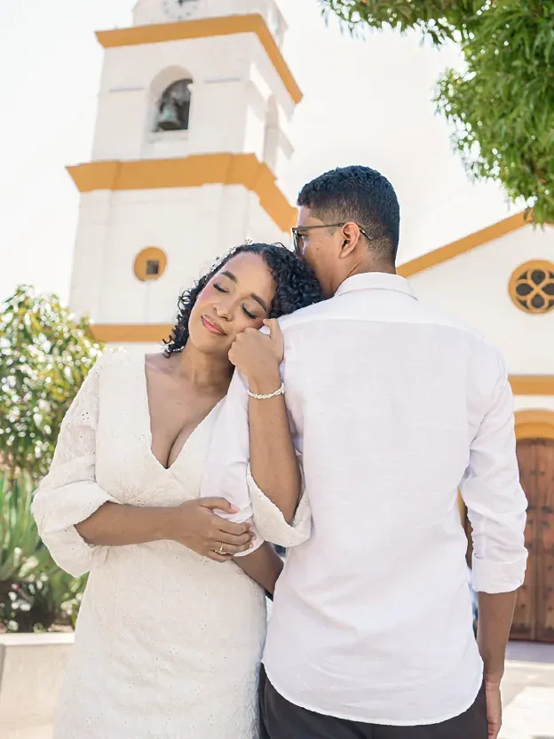 Brian y Lina abrazados frente a la torre de una iglesia